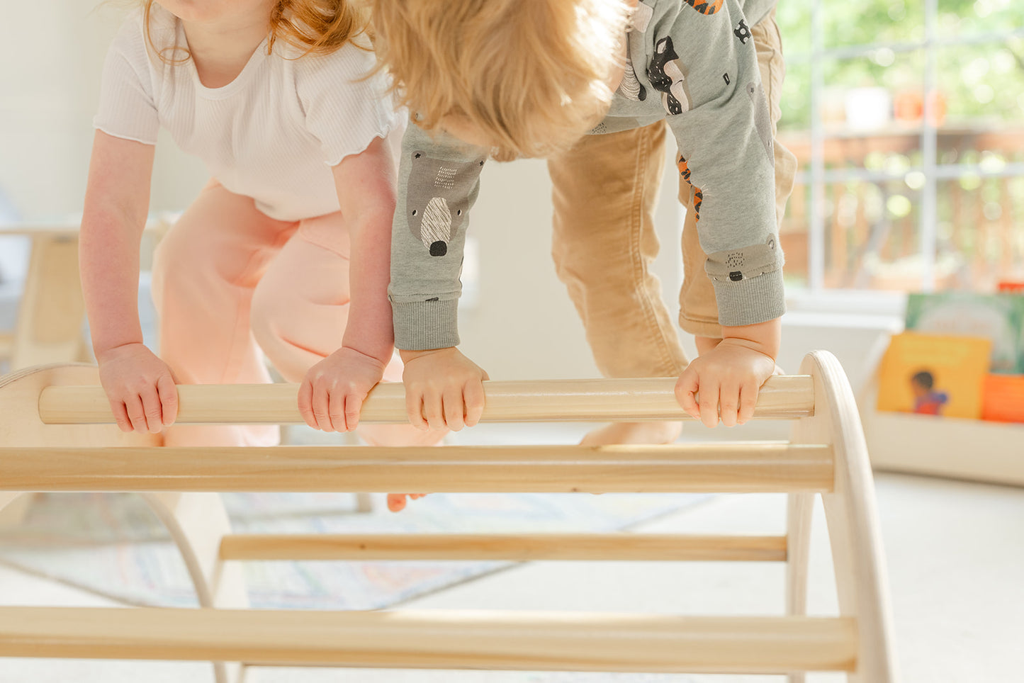 Blueberry and Third Pikler-style climbing arch with baby climbing toys nearby, natural wood arch supports crawling, pulling up, and gross motor milestones