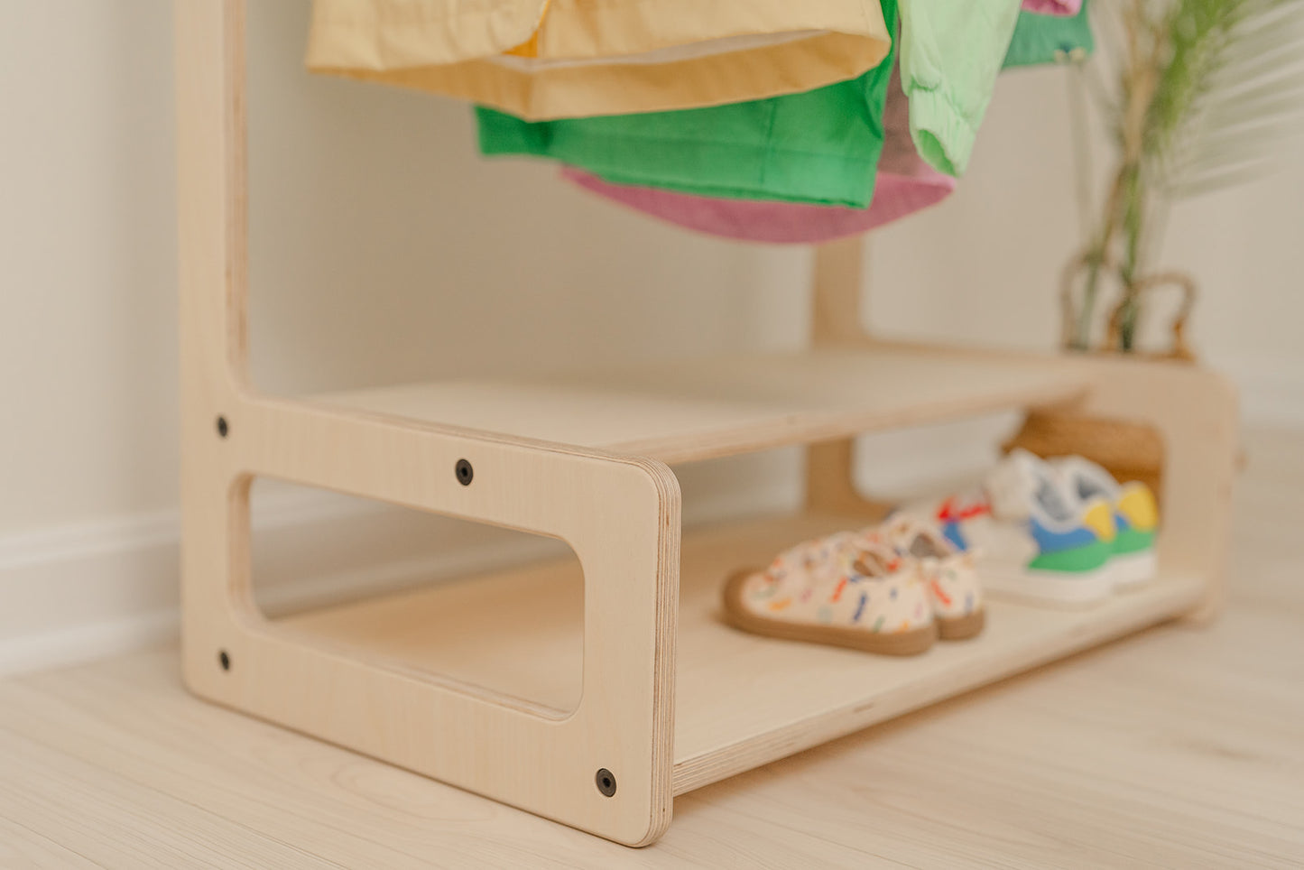shelves of wooden child size clothing rack and the shelves holding multiple sneakers in a organized manner