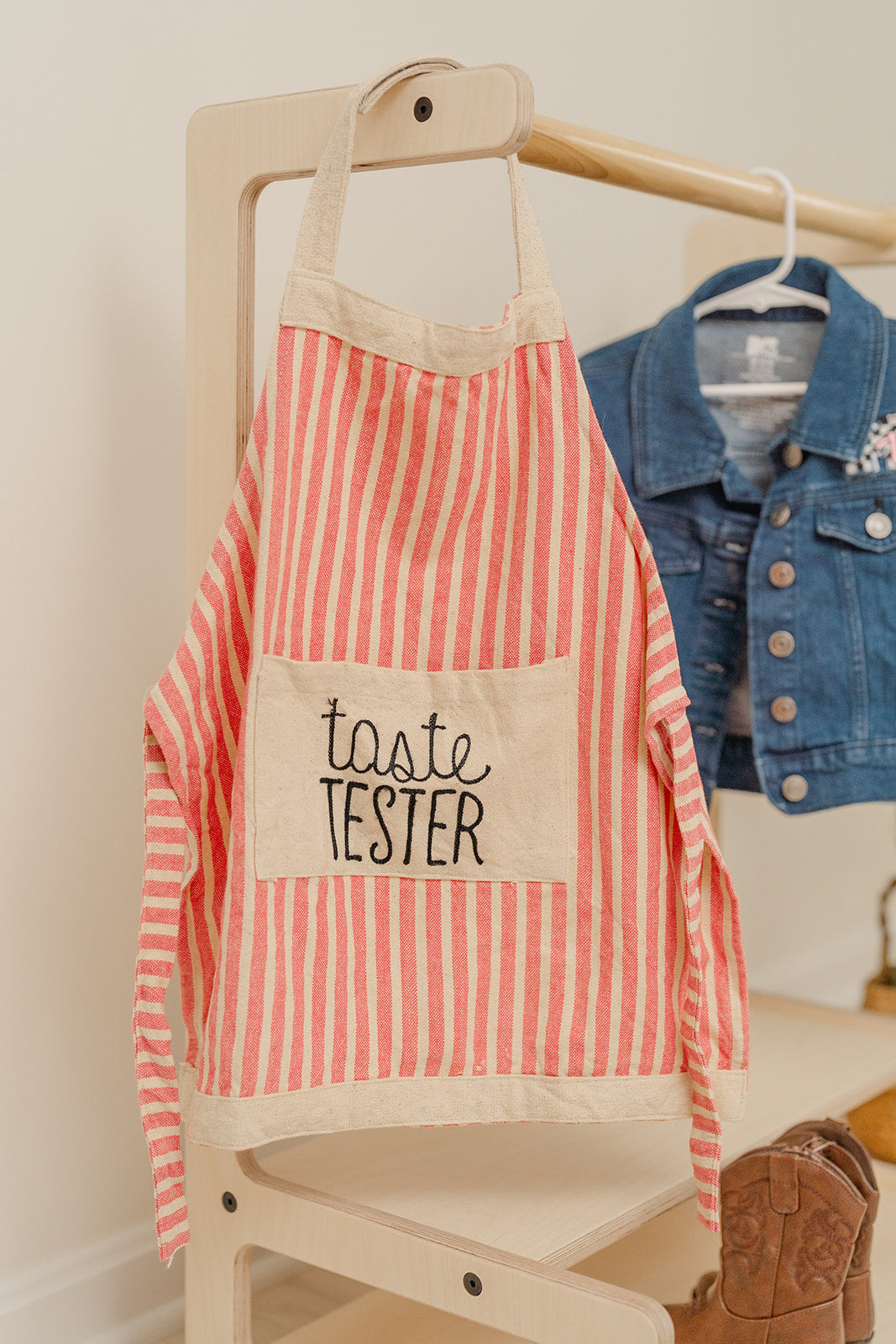 child size clothing rack with an apron and jean jacket hanging