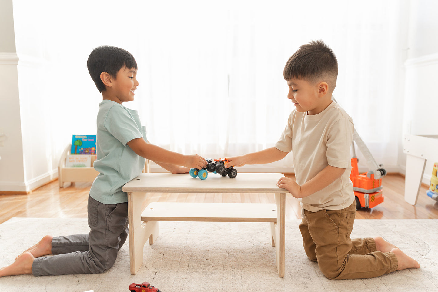Two siblings using Montessori step stool as toddler table and chairs for snack time and art activities, multi-functional kids helper stool converting from kitchen counter access to low seating surface, wooden learning stool doubling as children's activity table for eating coloring and playing, versatile toddler furniture for kitchen bathroom and playroom use throughout the home.playroom