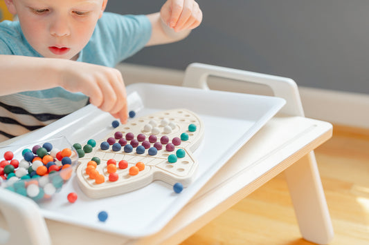 A child playing with a sensory toy rocketship activity board to improve hand-eye coordination
