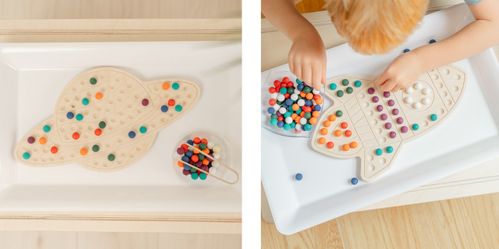 Two products photos of wooden activity boards. One is a wooden saturn with colorful balls placed on the saturn in a design. Next to wooden Saturn is a wooden rocketship with colorful balls placed in ROYGBIV order. The Activity boards are perfect for preschool, primary, and early elementary students 