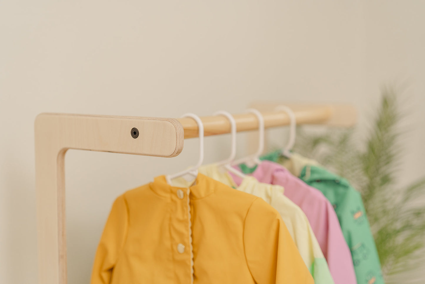 wooden child size clothing rack with kids jackets neatly hanging