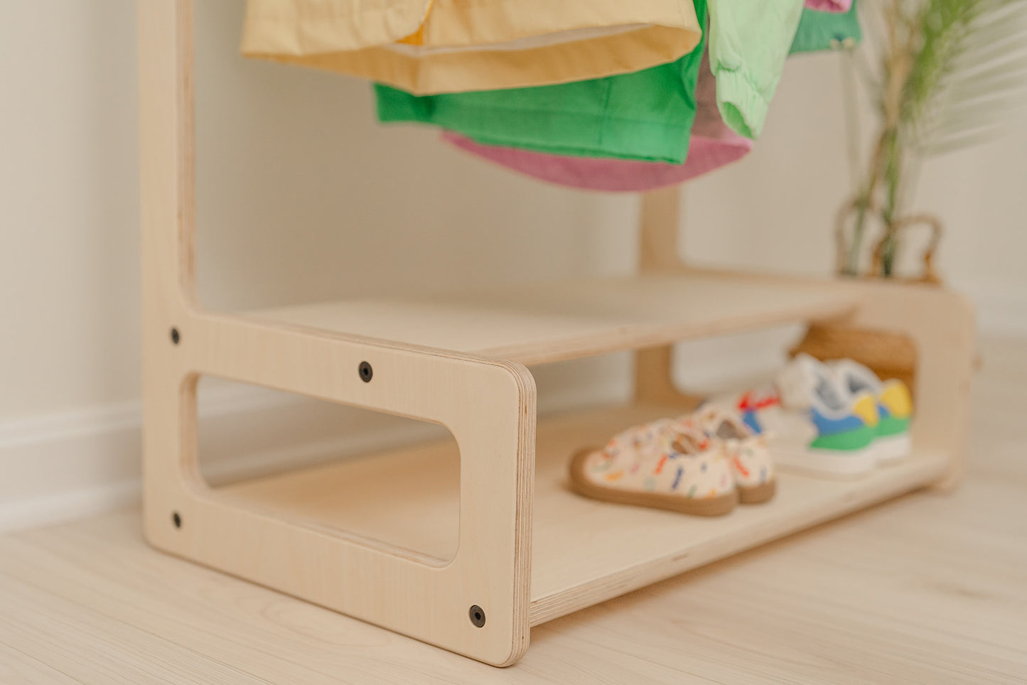 shelves of wooden child size clothing rack and the shelves holding multiple sneakers in a organized manner 