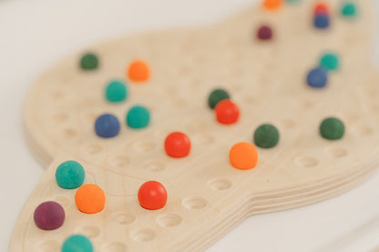 close up photo of colorful wooden balls on wooden saturn activity board great for ages 4-99