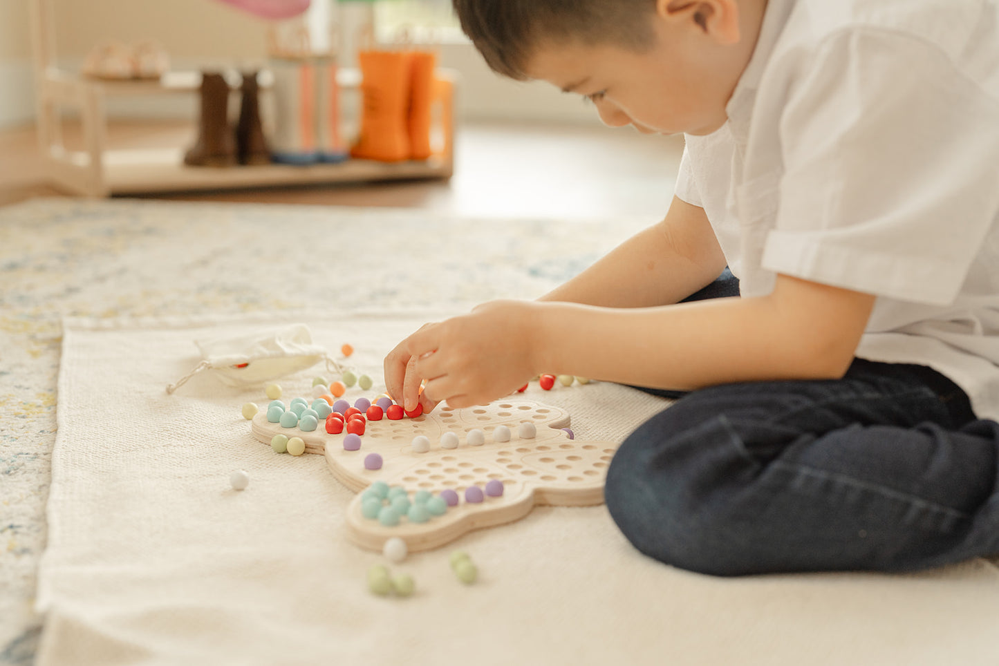 Two preschool children sharing wooden butterfly activity board during quiet independent play time demonstrating collaborative learning and turn-taking skills. Montessori peg board toy keeping kids ages 3-6 engaged and focused without screens. Calming sensory activity perfect for morning routine quiet time or transitions providing peaceful hands-on occupation while developing fine motor skills concentration and social interaction through shared educational play experience.