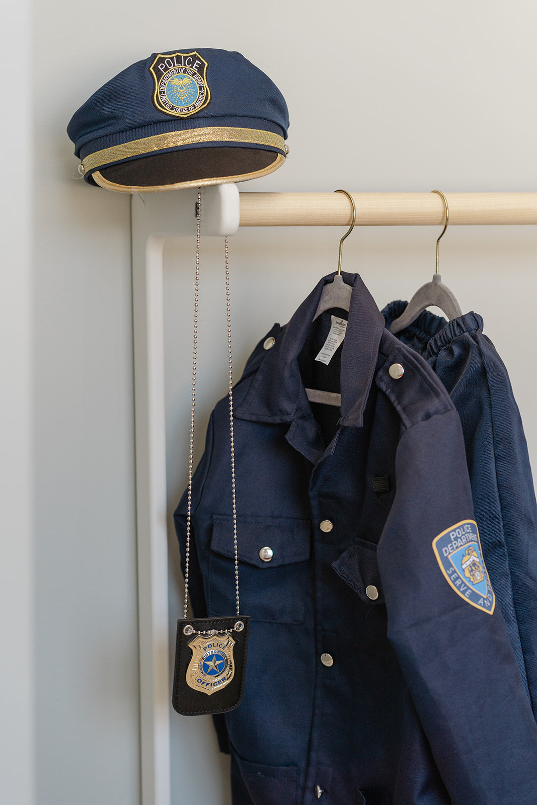 A costume rack with police dress up costumes for boys