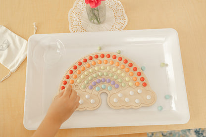 Montessori materials with wooden rainbow board and colorful wooden balls to place in rainbow shape and to make endless rainbow designs. There is canvas bag to hold the 140 wooden balls and bamboo tongs that are included.