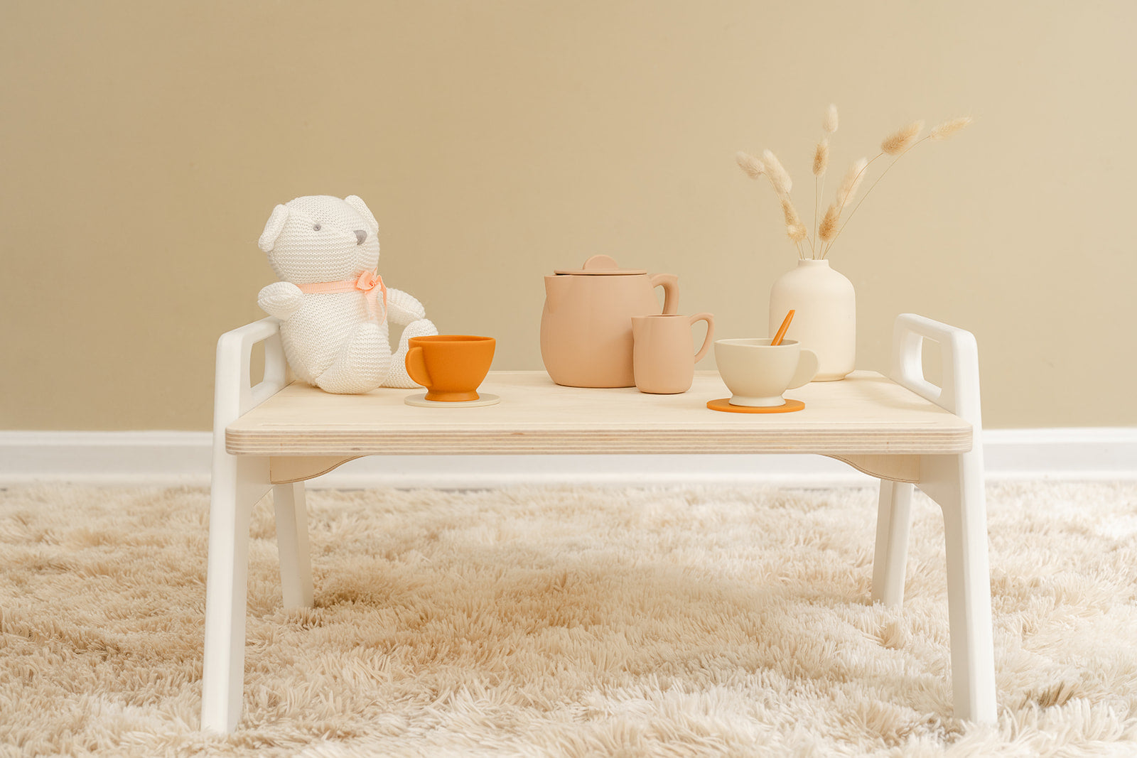A childrens play tray with a tea set on top ready to play with