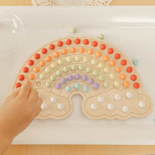 kids wooden rainbow board with colorful rainbow colored balls in rainbow shape