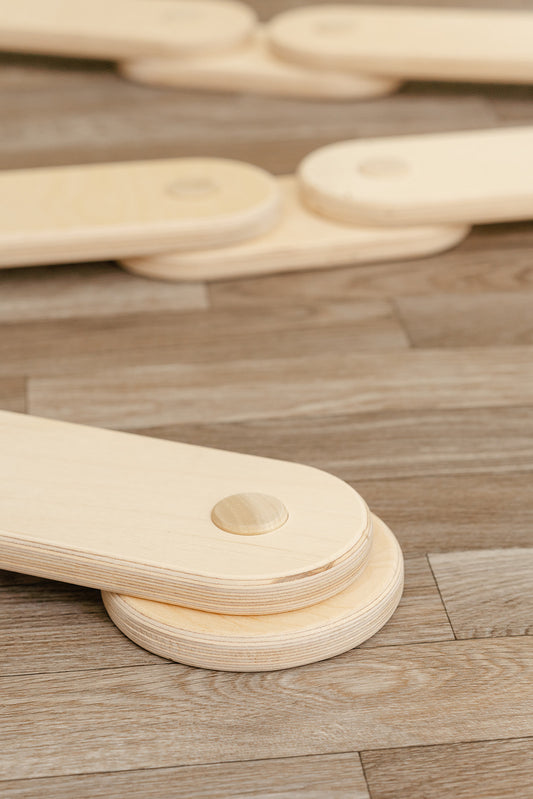 A close up of the rounded wooden base of a children's balance beam