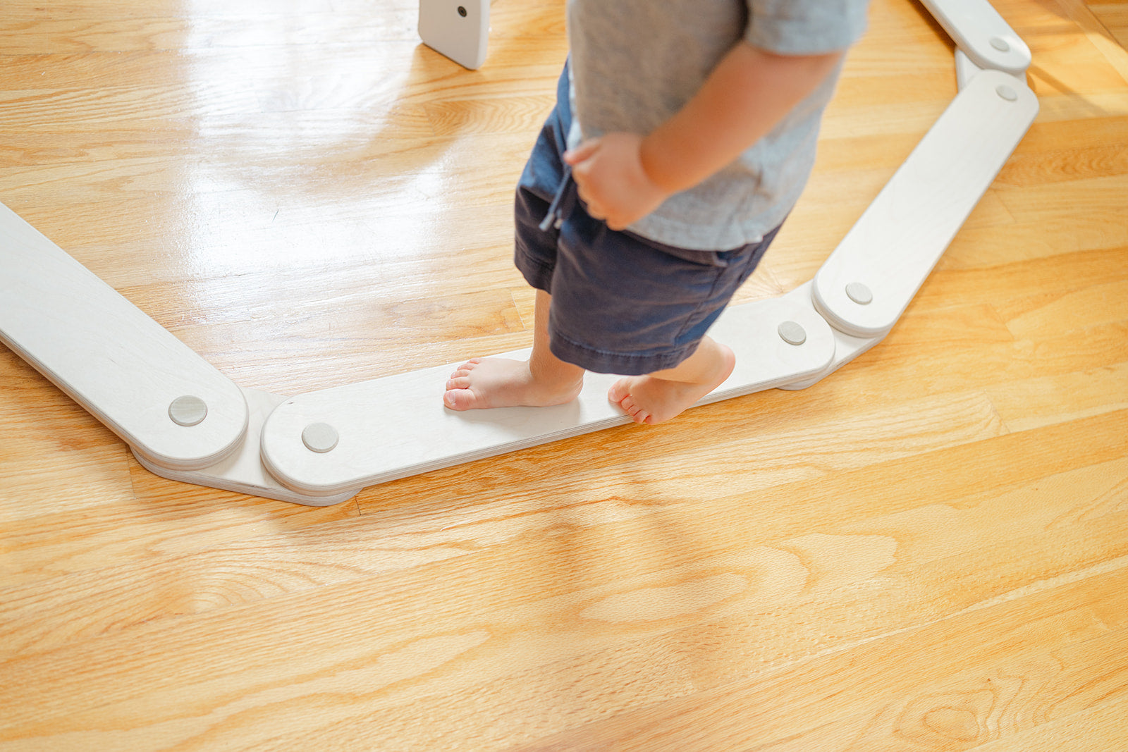A child walking on a short balance beam section