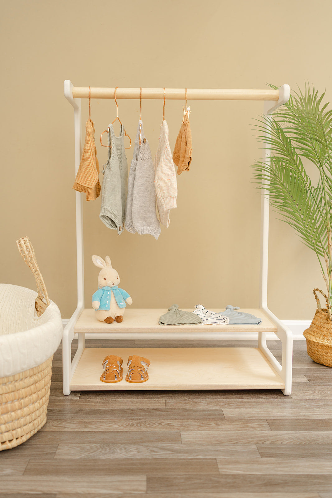 A kids clothing rack with bar and two shelves for boots or shoes