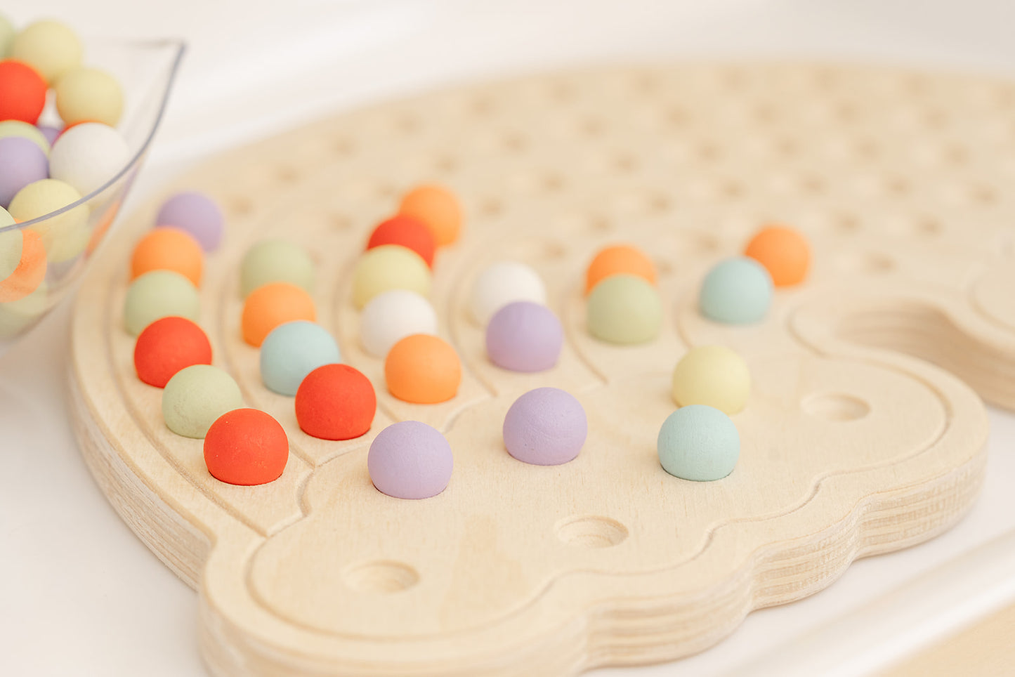 Product photo of Montessori wooden rainbow board. Our multi-colored balls add a sensory dimension to the learning experience and appeals to kids with ADHD by fulfilling their sensory needs and to focus on one activity.