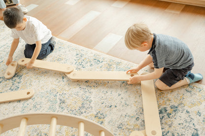 Close-up of wooden balance beam modular connectors showing easy no-tools assembly design, interlocking beam bases with pill-shaped and circular connectors enabling kids to independently reconfigure obstacle course shapes for STEM learning and problem-solving play