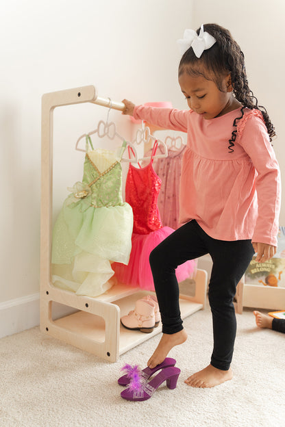 Two preschool boys independently selecting jackets from Montessori kids clothing rack in classroom setting demonstrating shared wardrobe organization, child-height garment rack with multiple hanging spaces for group childcare or sibling use teaching cooperation and personal belongings awareness, wooden toddler wardrobe in educational environment promoting practical life skills and autonomous dressing, children's clothing organizer supporting Montessori preschool curriculum and independence development.