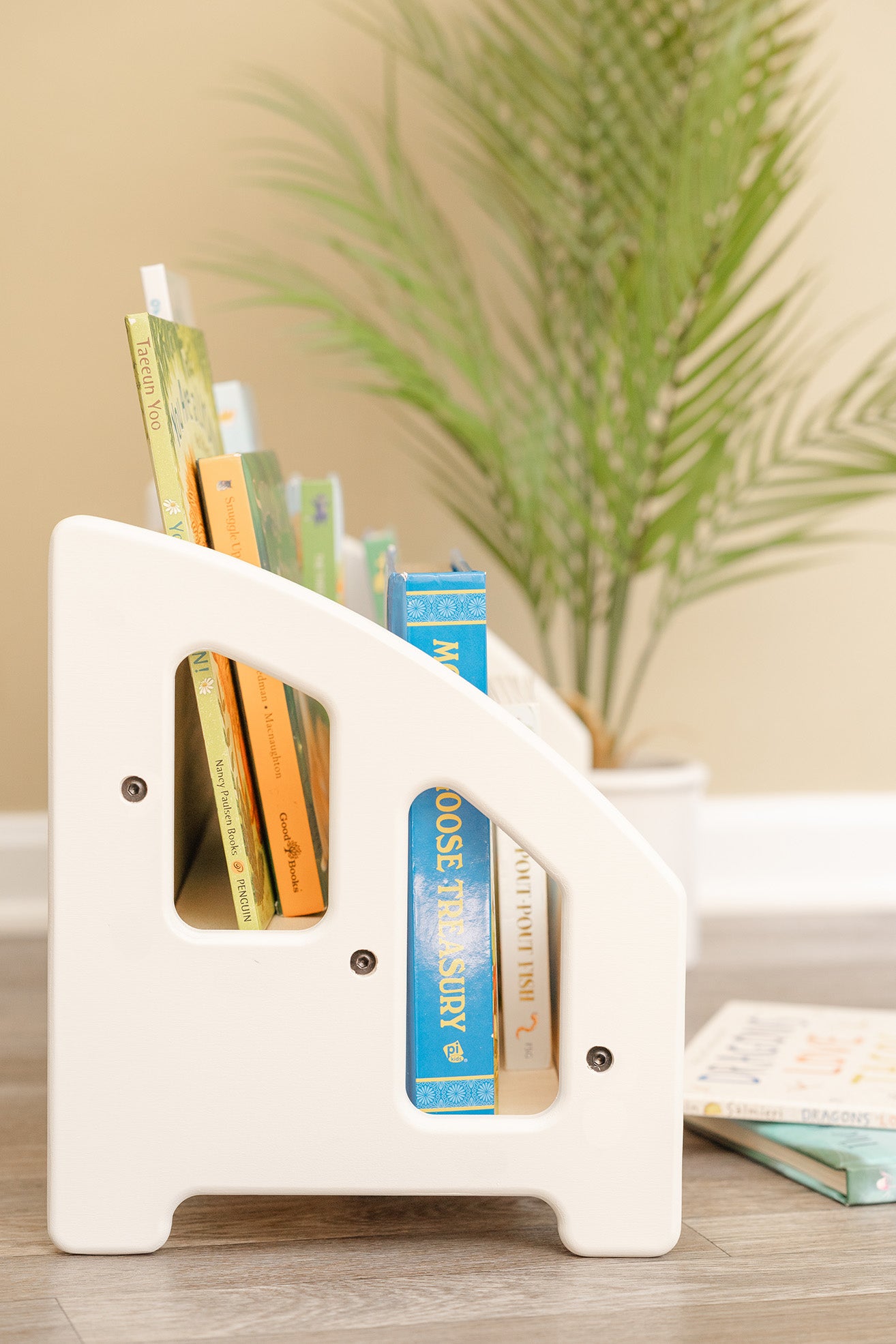 Side profile of a white kids bookshelf with open holes to easily see the books.