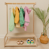 Montessori kids clothing rack with wooden dowel hanging bar and lower shelves for toddler wardrobe organization, child-height clothing organizer featuring natural birch construction for independent dressing and outfit selection, wooden kids garment rack with storage shelves for shoes and accessories encouraging practical life skills, USA-made children's clothing rack promoting autonomy and morning routine independence for ages 2-8 years.