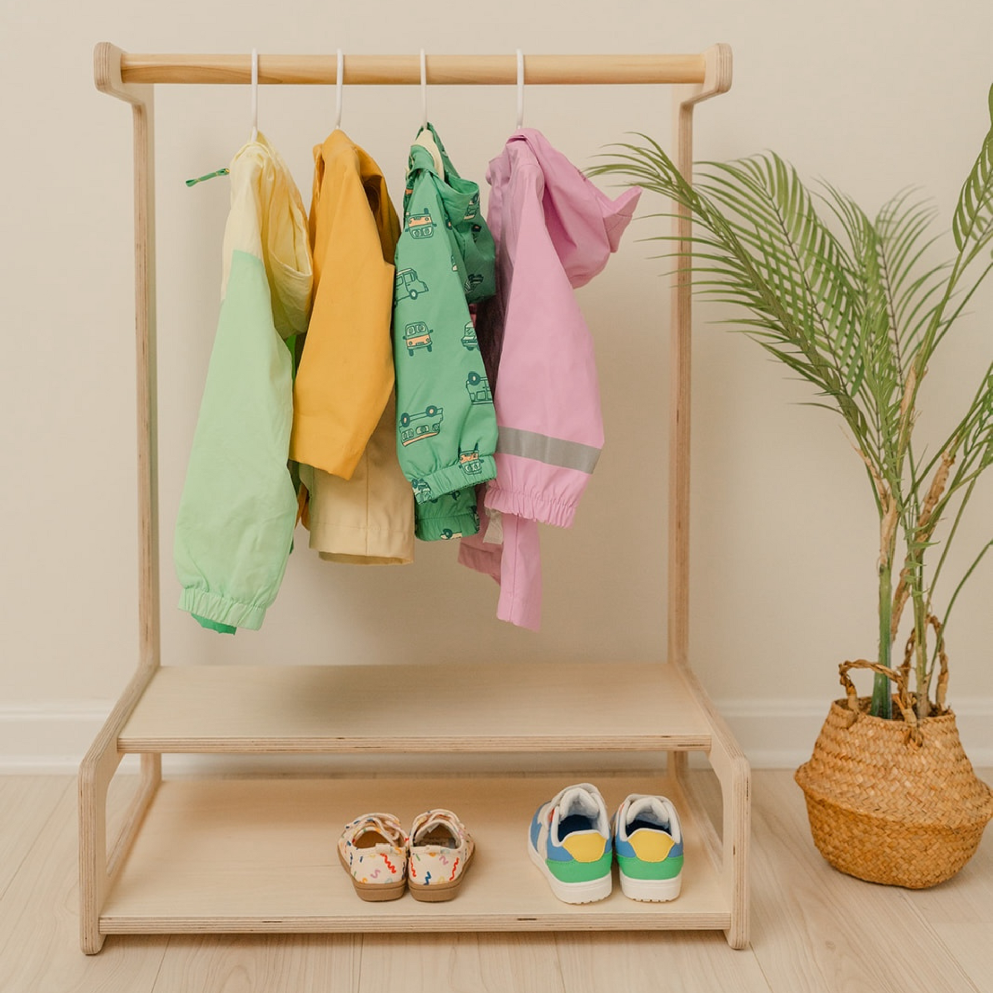 Montessori kids clothing rack with wooden dowel hanging bar and lower shelves for toddler wardrobe organization, child-height clothing organizer featuring natural birch construction for independent dressing and outfit selection, wooden kids garment rack with storage shelves for shoes and accessories encouraging practical life skills, USA-made children's clothing rack promoting autonomy and morning routine independence for ages 2-8 years.