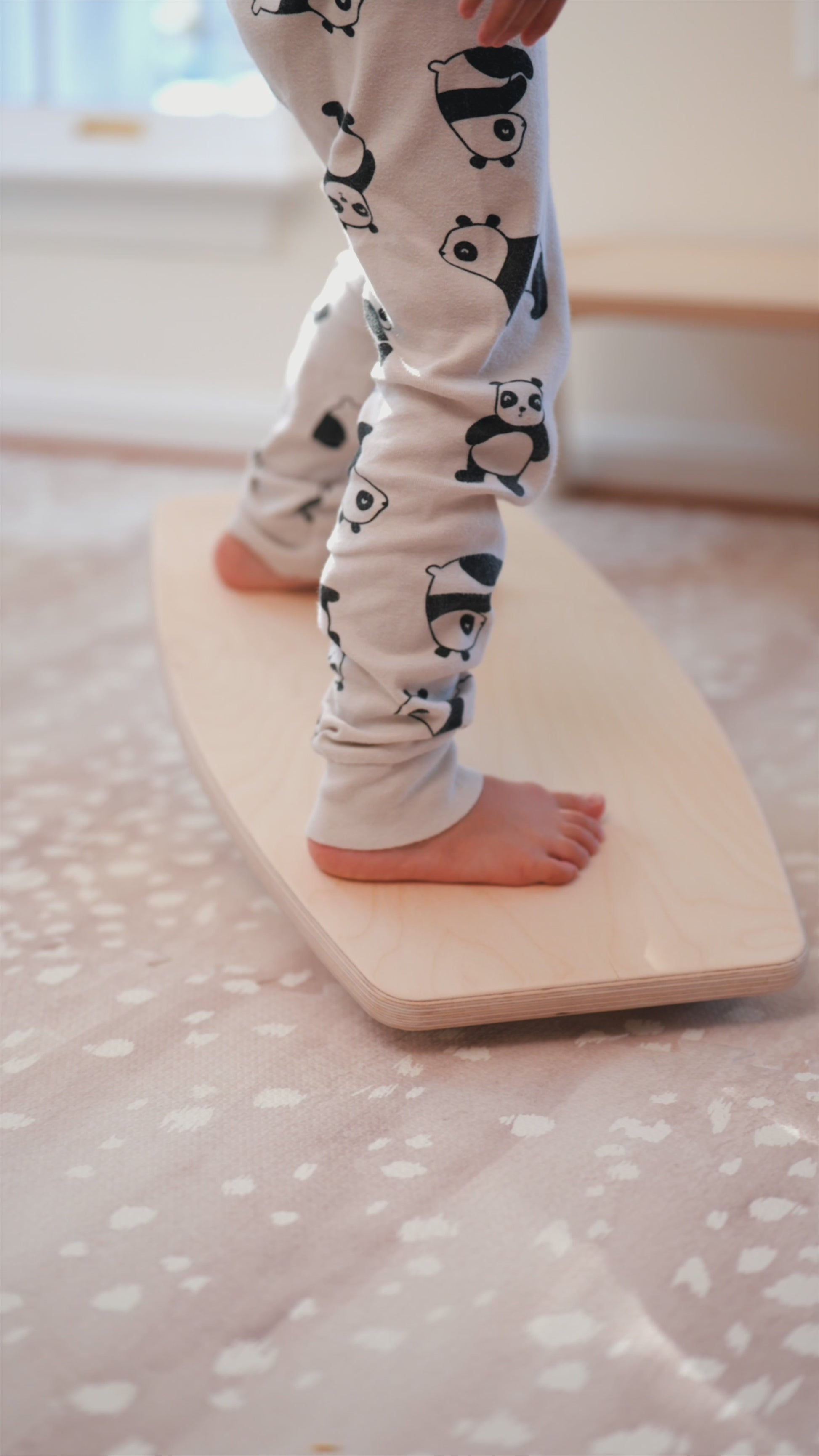 Child using a wooden balance board that rocks back and forth