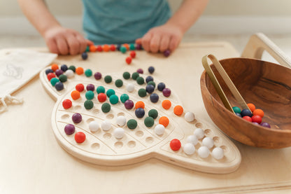 Elementary student working independently with wooden Saturn activity board at Montessori classroom table demonstrating focused hands-on learning and concentration. Educational peg board toy keeping kids ages 3-8 engaged and focused without screens during quiet work time. Space-themed STEM activity perfect for morning routine independent work or calming transitions providing peaceful hands-on occupation while developing fine motor skills problem-solving concentration and self-directed learning skills.