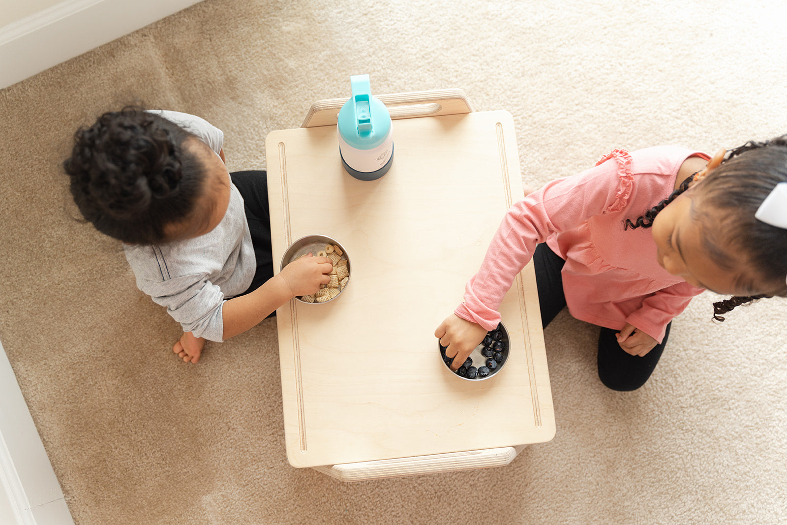 Wooden toddler activity table styled in modern minimalist playroom with neutral decor, portable Montessori play tray blending beautifully with home furniture while providing functional workspace for floor activities, small children's table complementing playroom bedroom or family room creating dedicated area for independent toddler activities and exploration