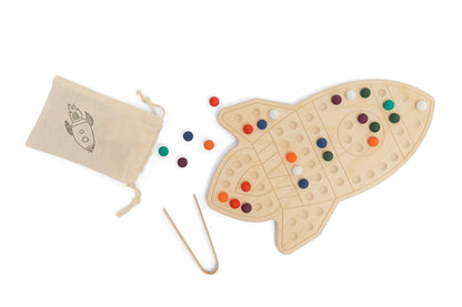 Creative pattern design made with colorful pegs on wooden rocketship activity board demonstrating open-ended play possibilities. Educational STEM toy encouraging children ages 3-6 to create unique designs developing spatial reasoning artistic expression and cognitive skills. Montessori sensory board promoting problem-solving and creative thinking through hands-on pattern recognition and color sorting in screen-free tactile play environment supporting early math and science concepts.
