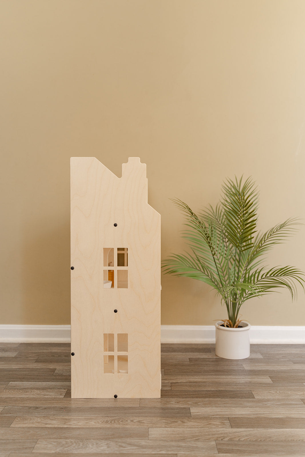Side profile of Georgian-style wooden dollhouse showing 3-story construction with symmetrical windows and Scandinavian-inspired clean lines, large life-size doll house featuring natural birch plywood finish that complements modern home decor, pretend play furniture piece designed for playroom bedroom or family room blending functionality with timeless aesthetic appeal for years of imaginative play