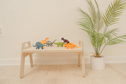 Parent easily moving portable wooden toddler table from room to room demonstrating lightweight mobile design, compact play tray perfect for small spaces apartments and multi-room use, Montessori floor table with convenient size allowing toddlers to have dedicated activity space anywhere in home for crafts sensory play or snacks