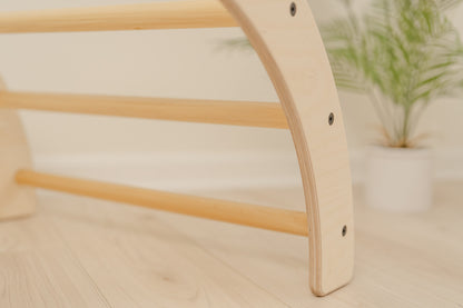 Handcrafted wooden climbing arch made in USA from sustainable Baltic birch plywood showcasing quality construction and timeless design, Montessori Pikler arch for toddlers with smooth-sanded rounded edges and nine sturdy handles providing safe climbing surface, versatile toddler climbing gym for indoor active play promoting gross motor development coordination balance and physical confidence in children ages 10 months to 8 years up to 100 pounds.