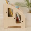 Beautiful side profile of Montessori bookshelf for toddlers featuring two-tier shelf design with forward-facing book display at low child-accessible height promoting independent book selection and early literacy development, wooden kids bookshelf handcrafted and rounded edges for safe use in nursery or playroom, heirloom-quality book display shelf supporting Montessori method of order, organization, and lifelong love of reading, made in USA with deep shelves allowing several books to be on display
